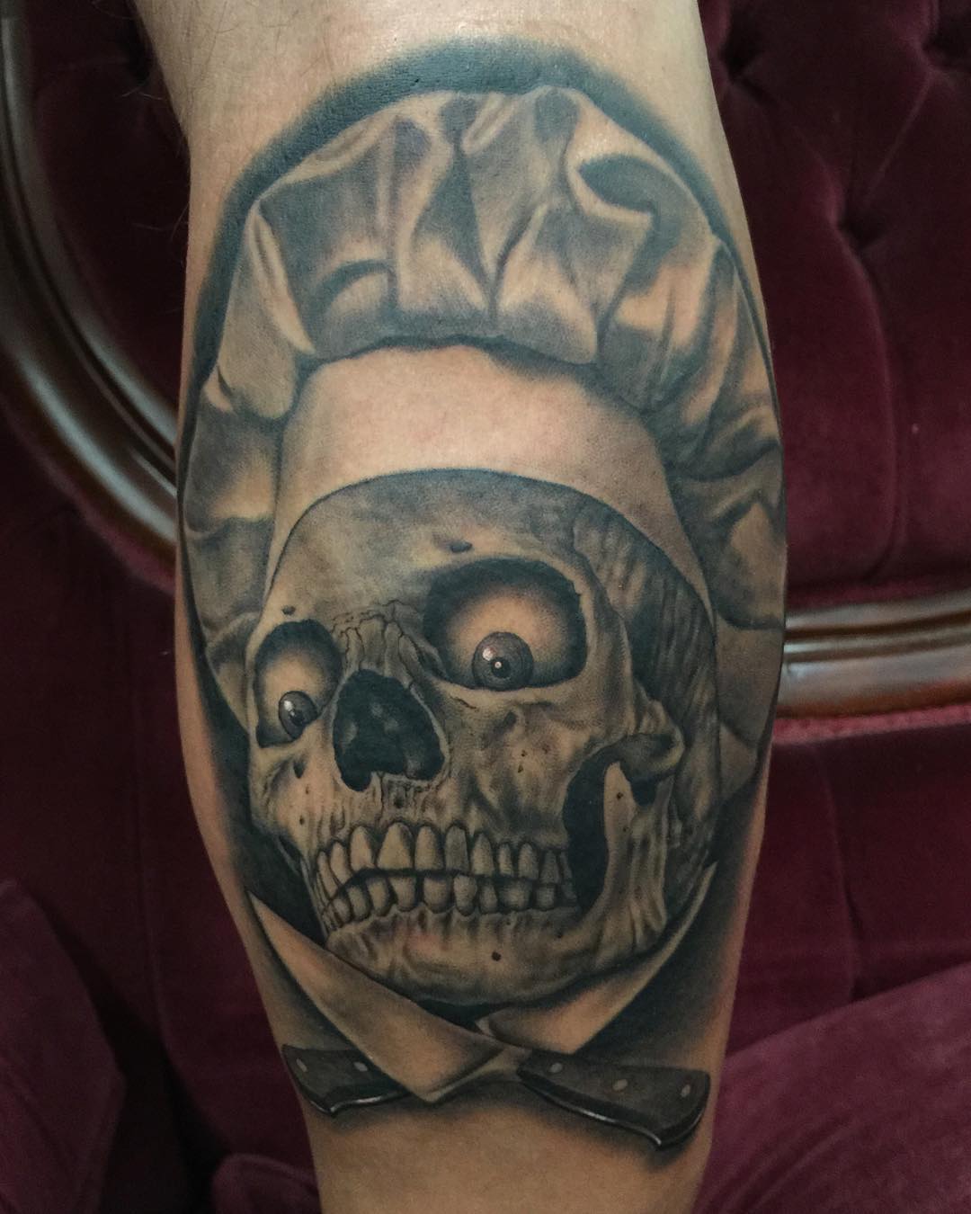 the skull in chef's hat with crazy eyes and two knifes