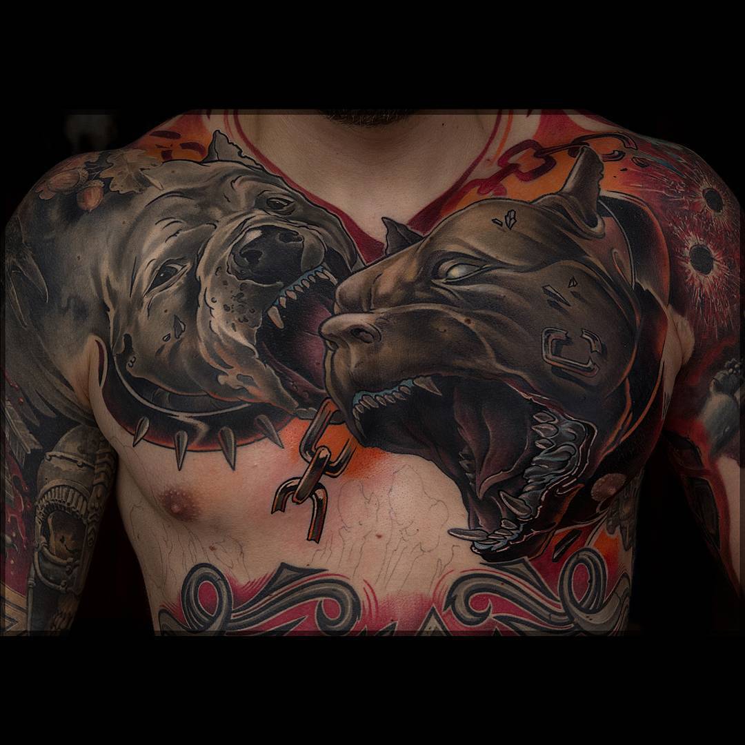 a big chest tattoo of two angry dogs