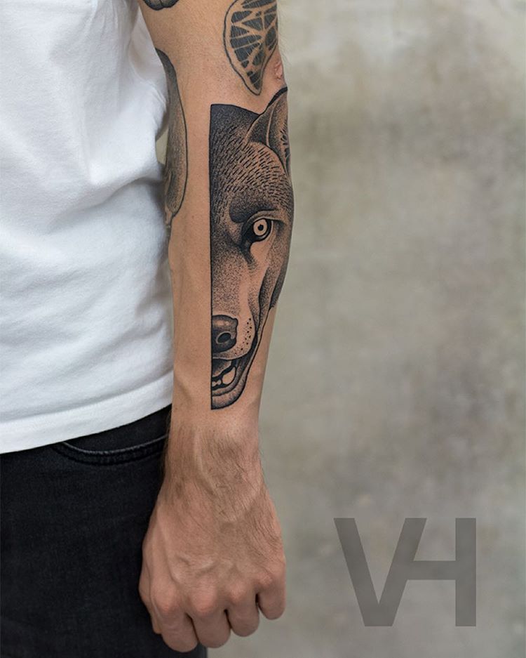 a tattoo on arm of the half of the wolf's face