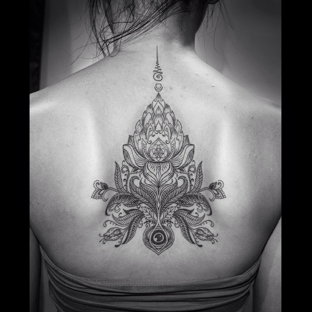 detailed religious drawing of the lotus flower between shoulder blade