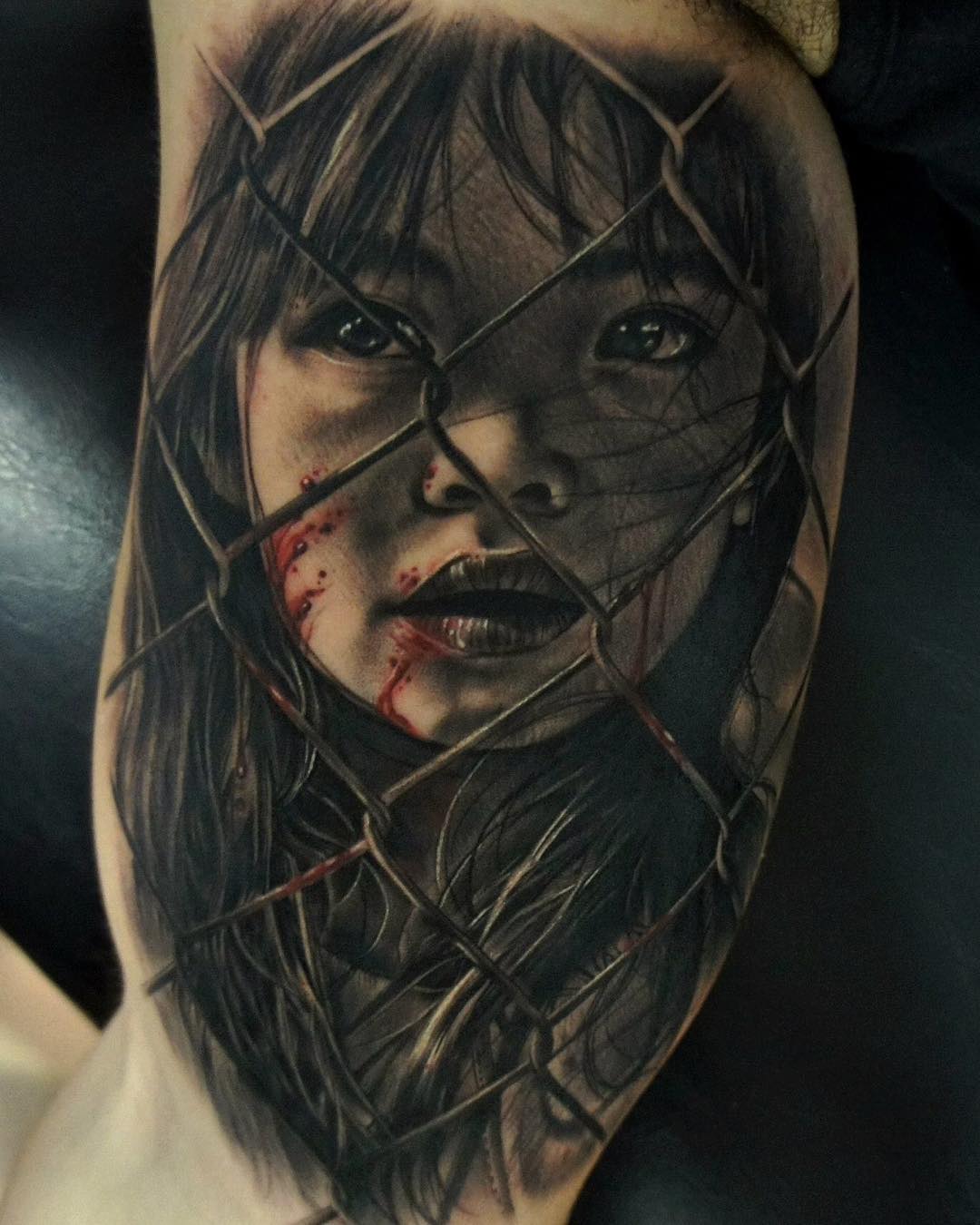 the black and grey portrait of a girl behind the fence - realistic tattoo