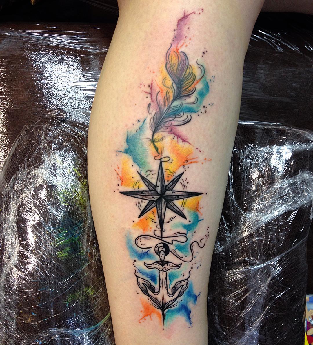 watecolor colorful background tattoo of a nautical star on arm