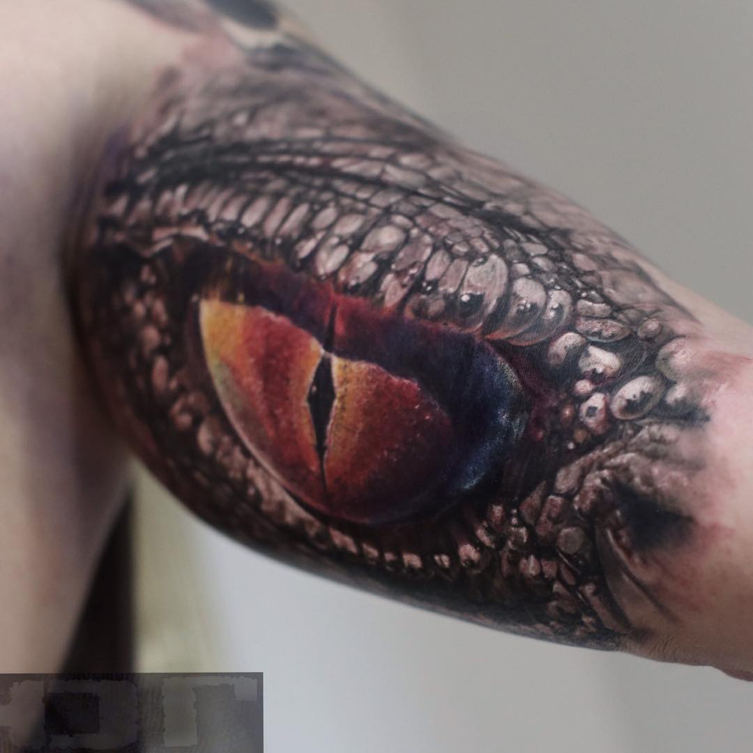 eye of a snake tattoo on bicep