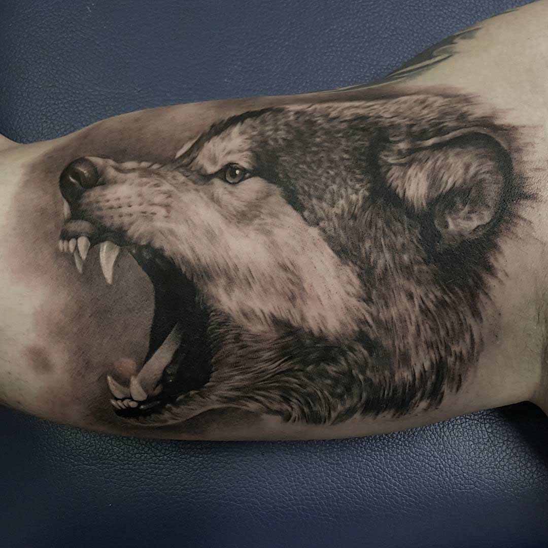 angry wolf tattoo on bicep