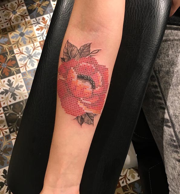 cross stitch rose tattoo on arm