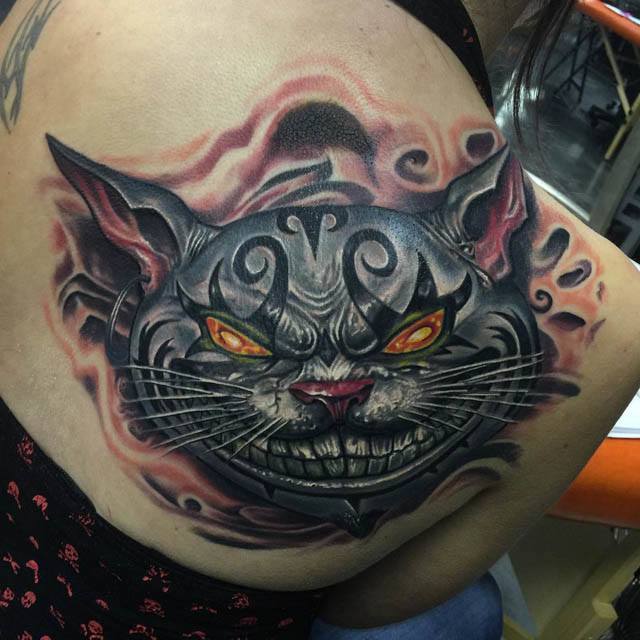 shoulder blade chesire cat tattoo evil