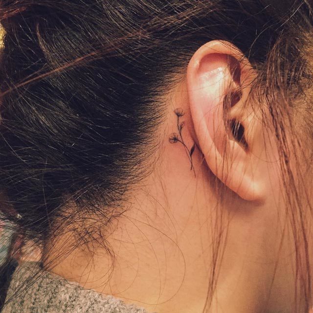 tiny flowers tattoo behind the ear