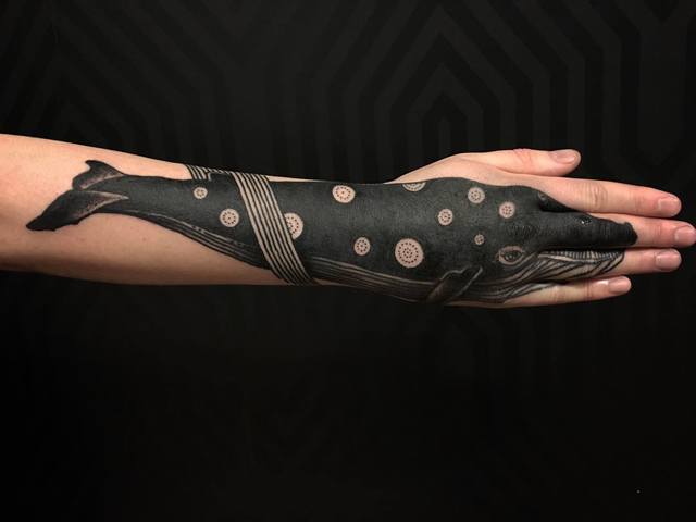 blackwork whale tattoo on hand