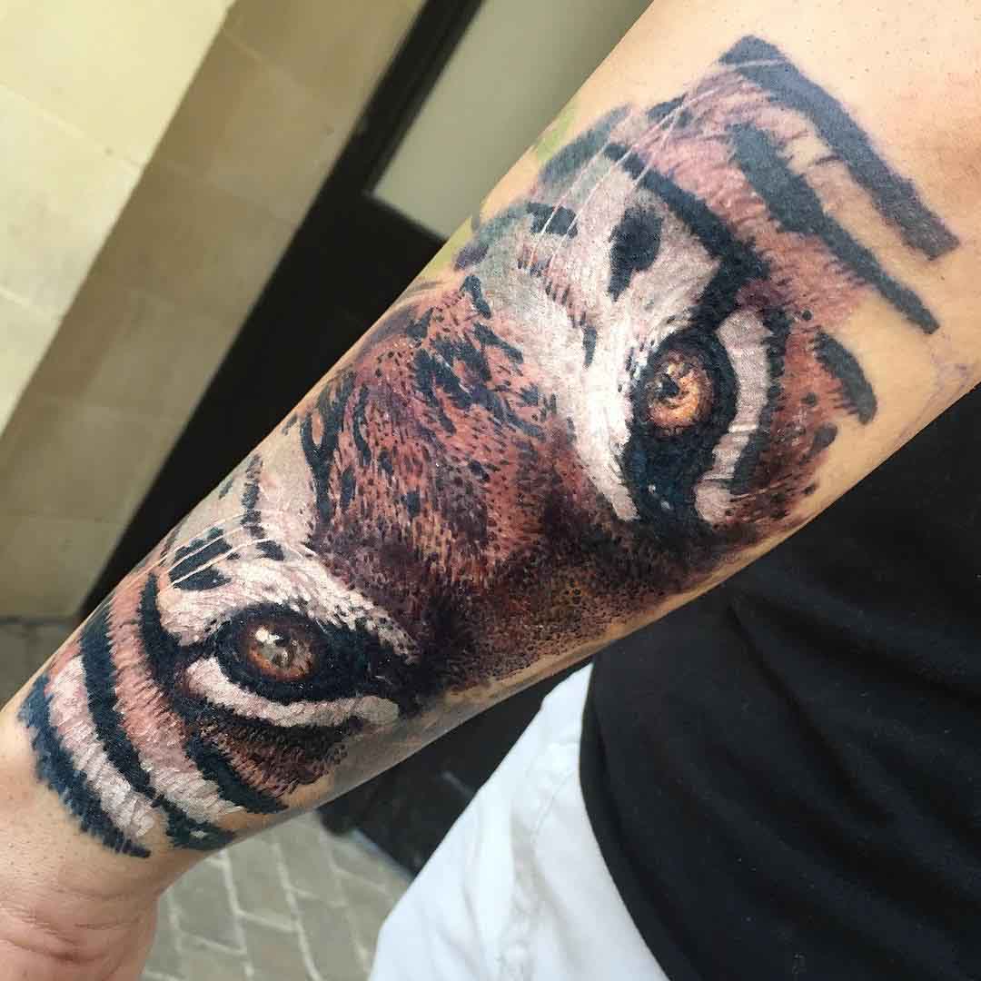 eyes of tiger tattoo on forearm