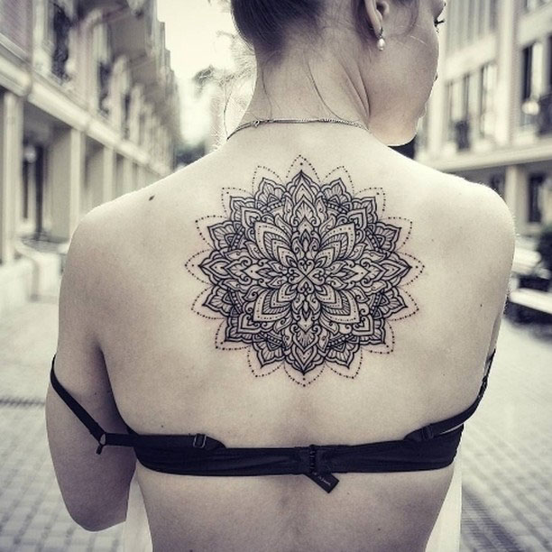 Girl back tattoo mandala between shoulder blades