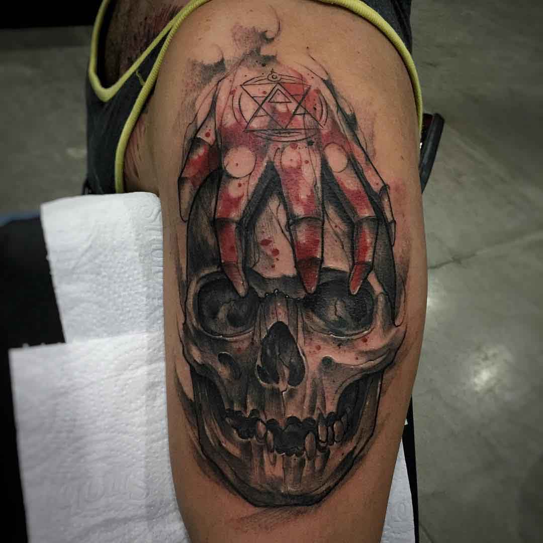 skull with hand tattoo on shoulder