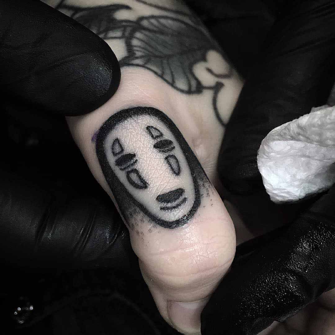 spooky mask tattoo on finger thumb