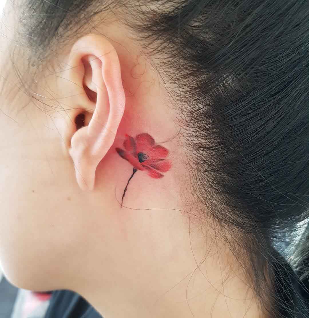 little poppy tattoo behind the ear