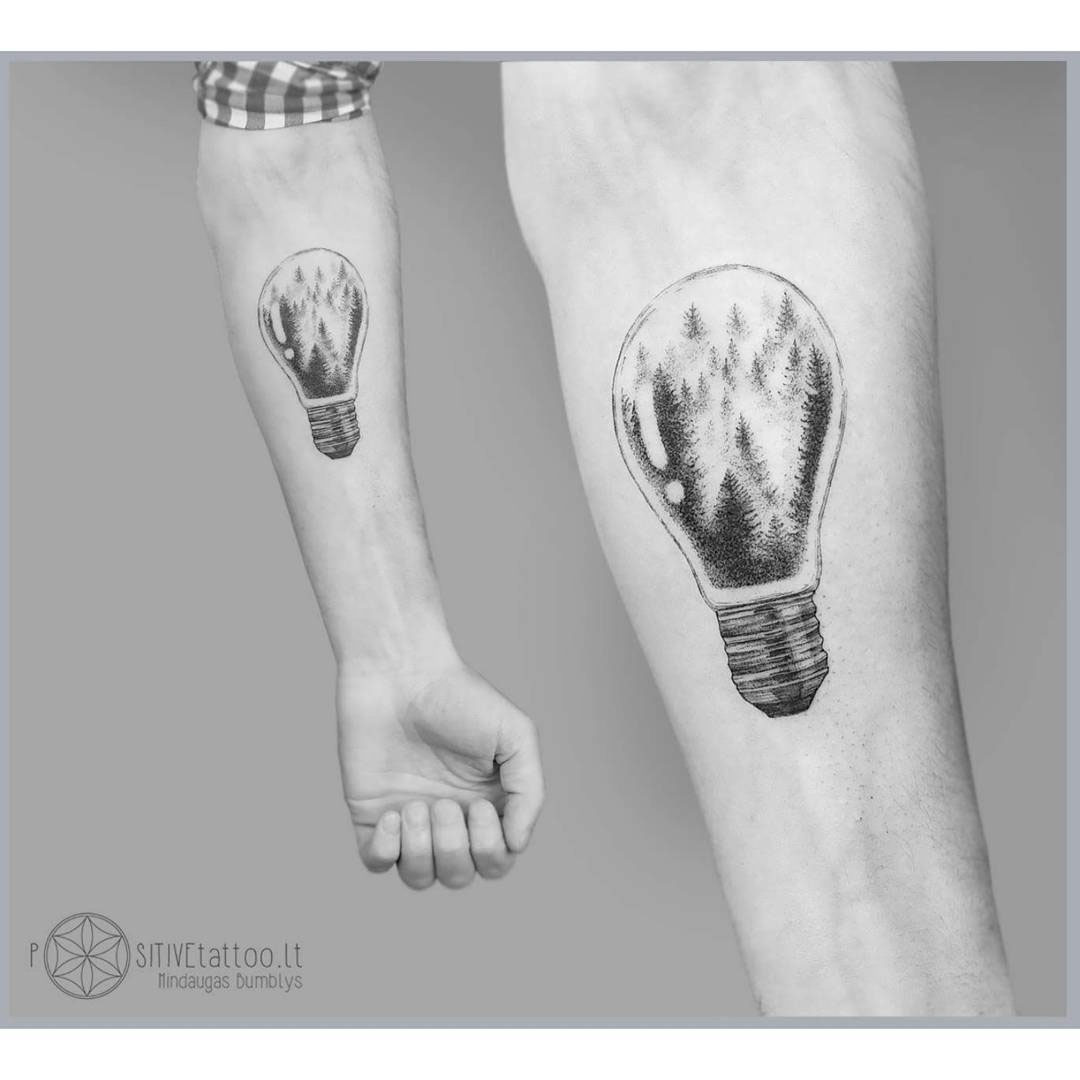 forearm tattoo lightbulb with forest inside
