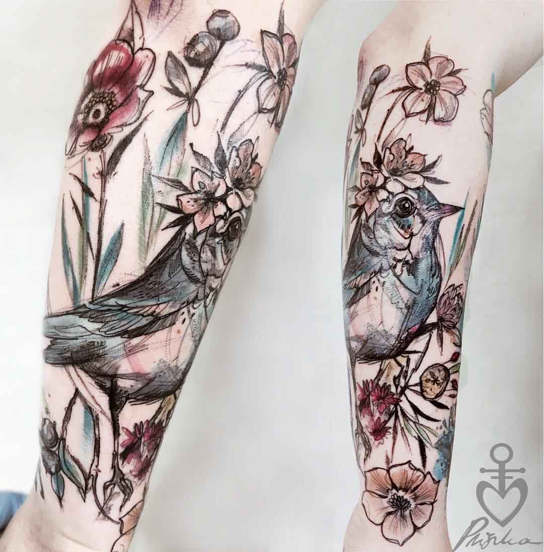 bird in flowers tattoo on forearm