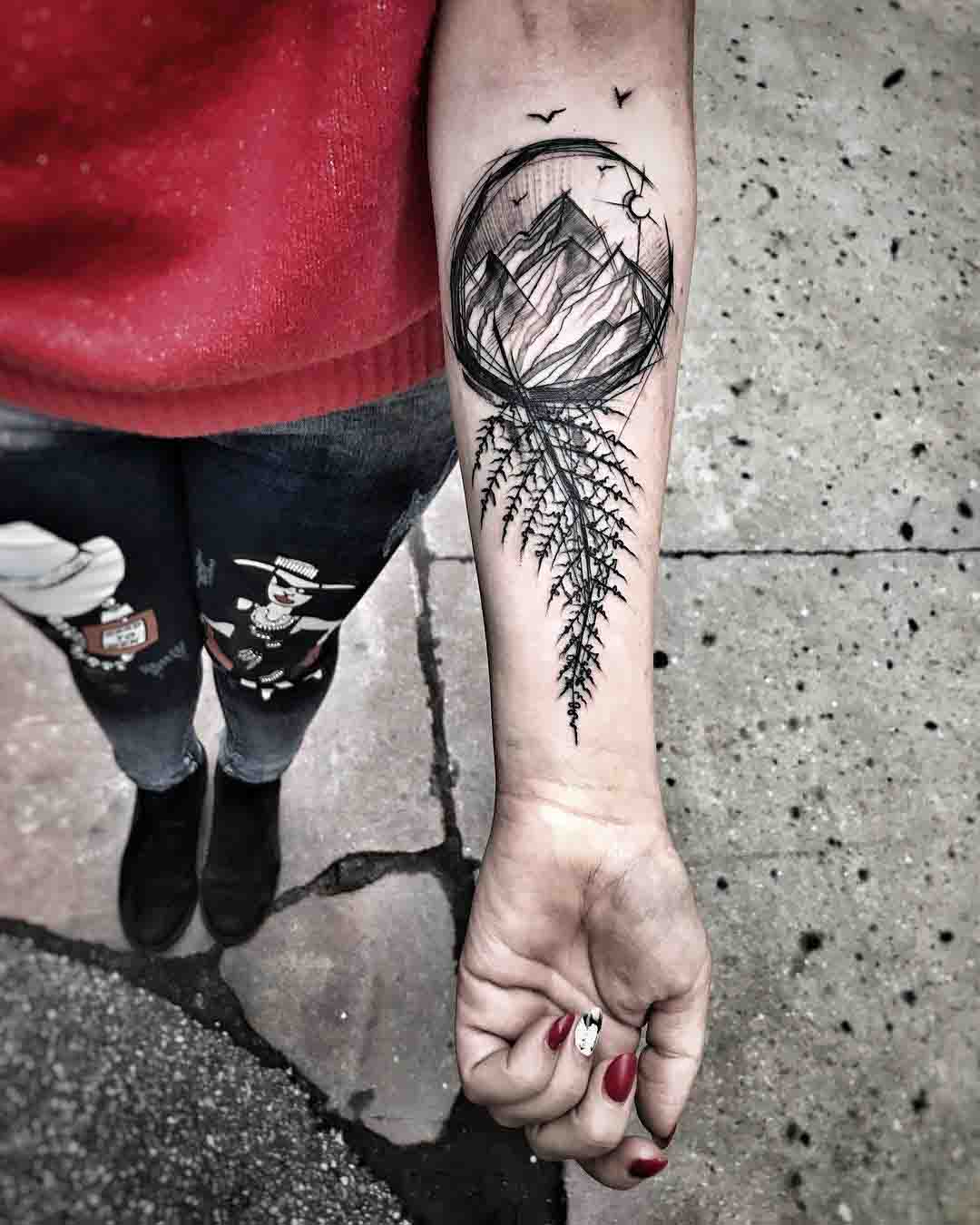 forearm tattoo mountain and fern