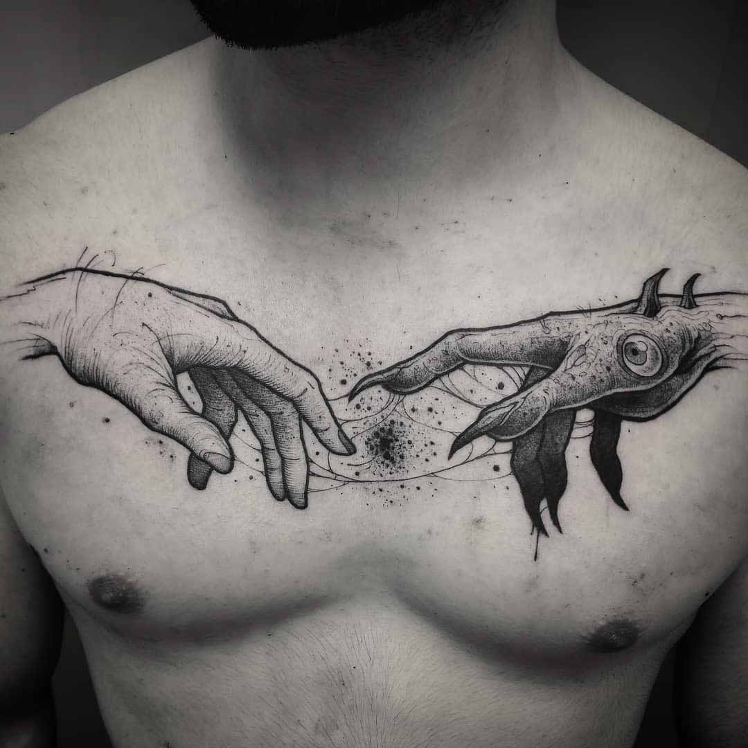 chest tattoo demonic hand and human hand